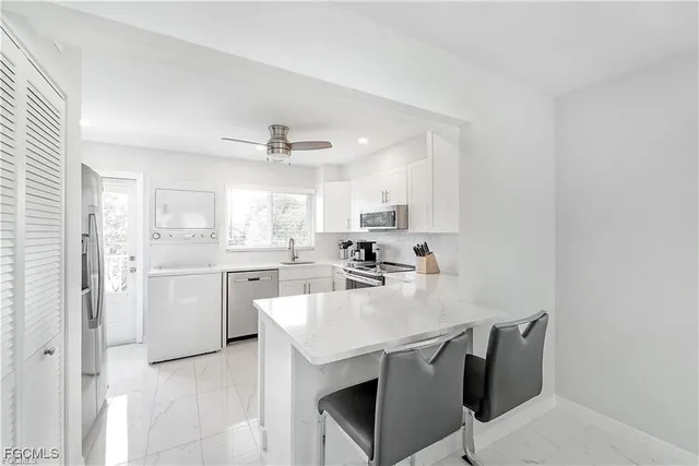 a kitchen with cabinets and chairs