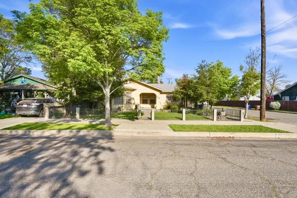 a view of house with outdoor space and trees in the background