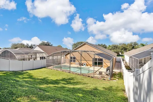 a view of a white house with a big yard and large trees