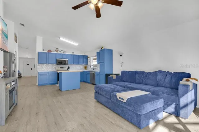 a living room with furniture and kitchen view