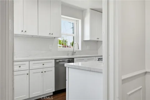 a kitchen with white cabinets and white appliances