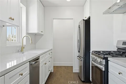 a kitchen with stainless steel appliances a sink stove and refrigerator