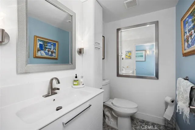 a bathroom with a sink mirror and toilet