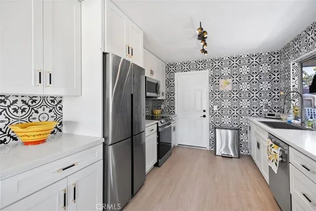 a kitchen with stainless steel appliances granite countertop a refrigerator a stove and a sink
