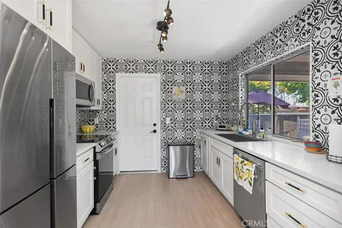 a kitchen with stainless steel appliances granite countertop a sink and a refrigerator
