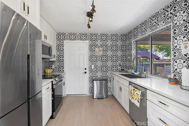 a kitchen with stainless steel appliances granite countertop a sink and a refrigerator