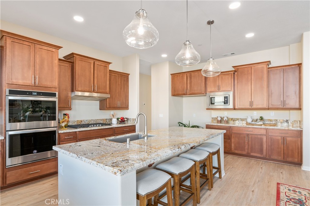 a kitchen with kitchen island granite countertop a sink and stove
