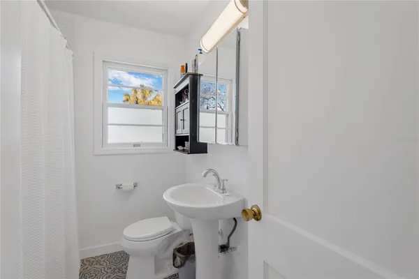a bathroom with a sink toilet and a mirror