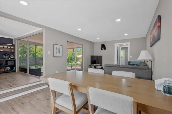 a living room with furniture a large window and wooden floor