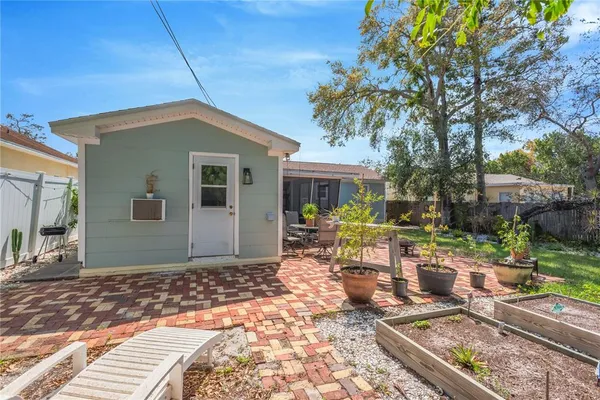 a view of a house with backyard sitting area and a garden