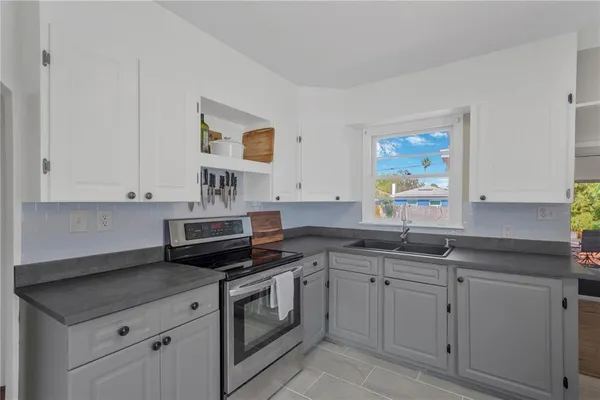 a kitchen with white cabinets and sink