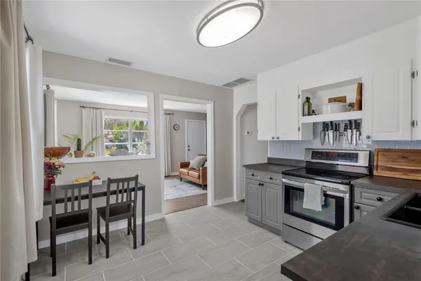 a kitchen with stainless steel appliances a stove a table and chairs in it