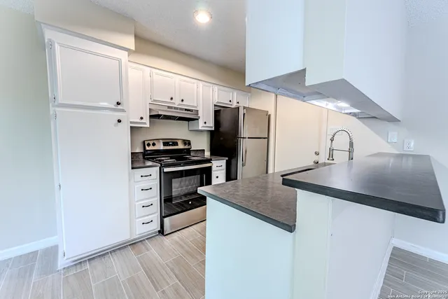 a kitchen with kitchen island stainless steel appliances a sink and a refrigerator