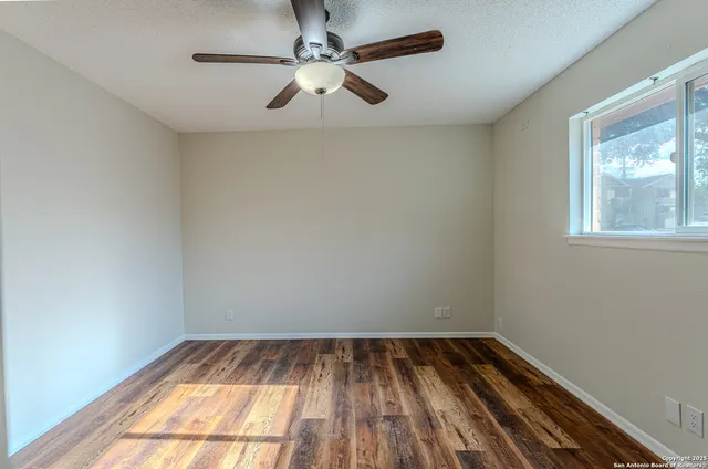 a view of empty room with wooden floor