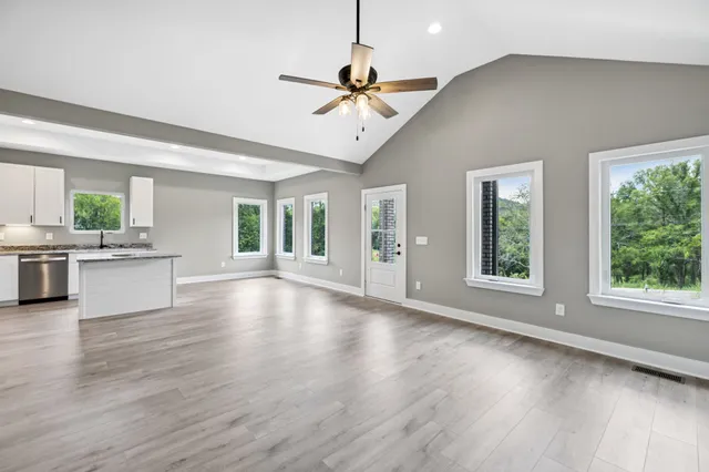 a view of a livingroom with furniture hardwood floor and windows