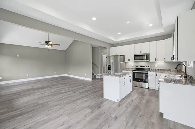 a kitchen with white cabinets and stainless steel appliances