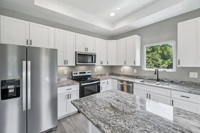 a kitchen with stainless steel appliances granite countertop a refrigerator sink and stove