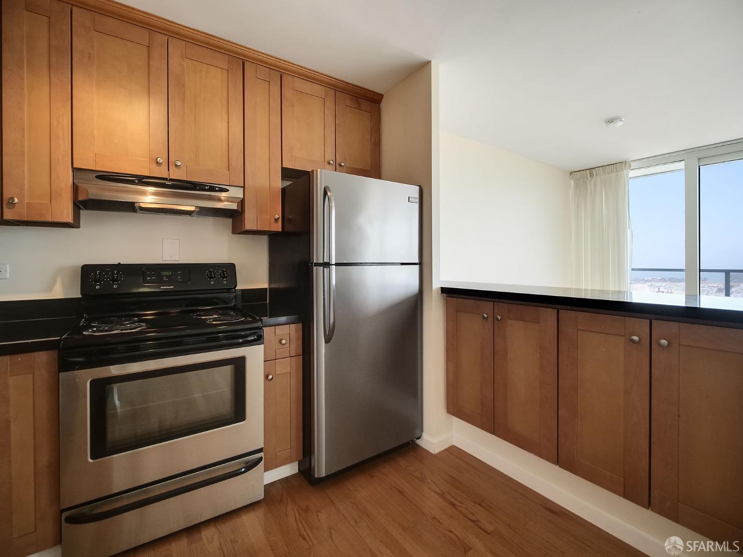 1800 Pacific Avenue, Unit 701 San Francisco, CA 94109 - Photo 16 of 36 a kitchen with a refrigerator stove and cabinets