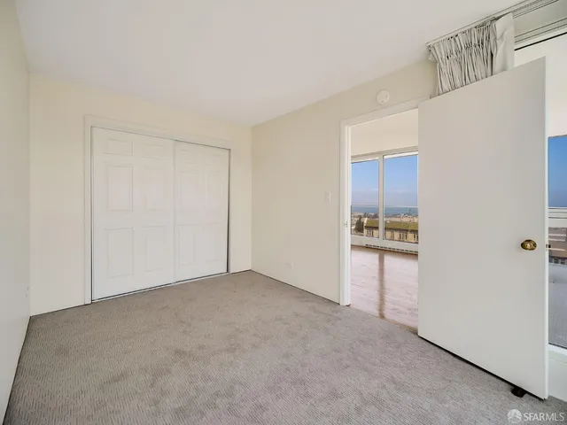 a view of an empty room and kitchen view