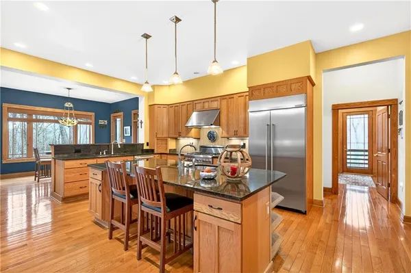 a kitchen with stainless steel appliances a dining table chairs and wooden floor