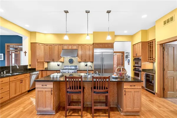 a kitchen with granite countertop a stove a sink and a wooden cabinets