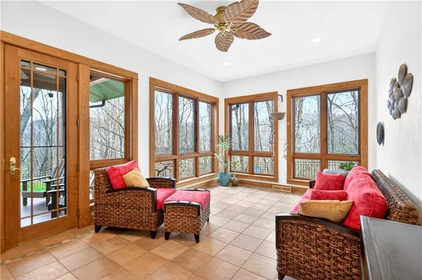 a living room with furniture and floor to ceiling windows