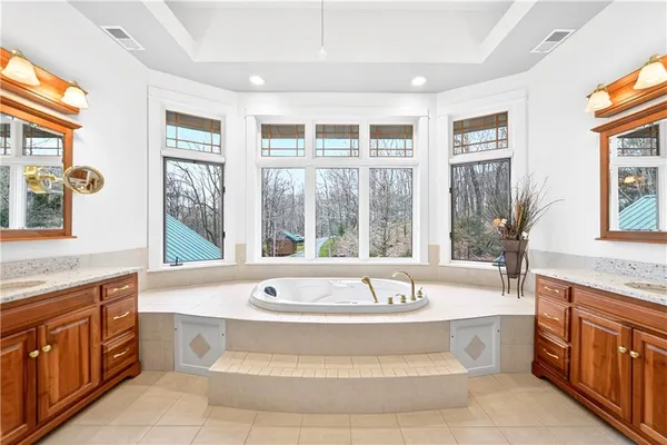 a spacious bathroom with a tub double sink and mirror