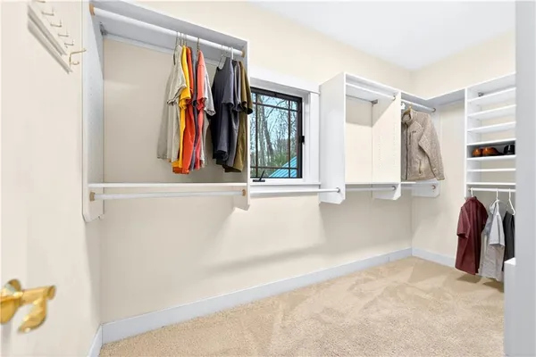 a view of walk in closet with clothes and shoes
