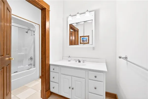a bathroom with a double vanity sink a mirror and a bathtub