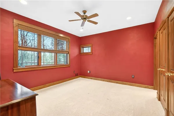 an empty room with windows and ceiling fan