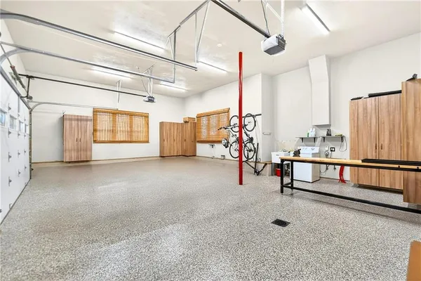 a front view of a house with garden and a tree