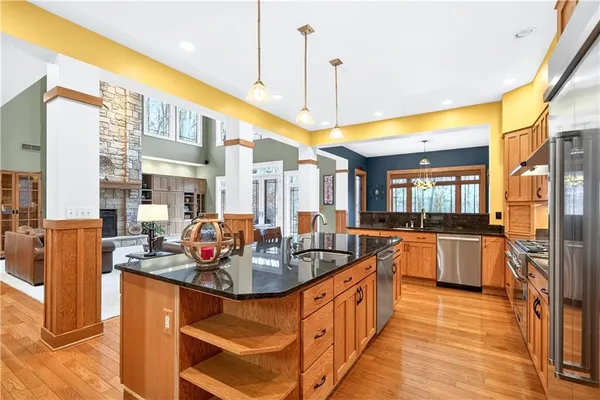 a large kitchen with stainless steel appliances granite countertop a sink and cabinets