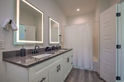 a bathroom with a double vanity sink and mirror