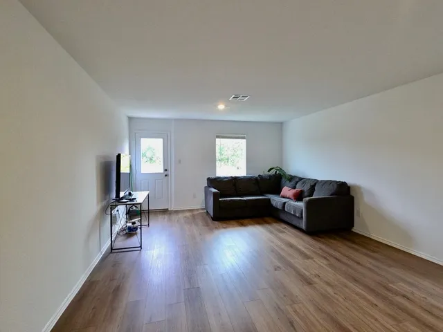 a living room with furniture and a wooden floor