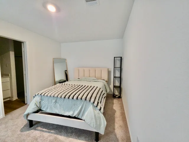 a bedroom with a bed and a night stand