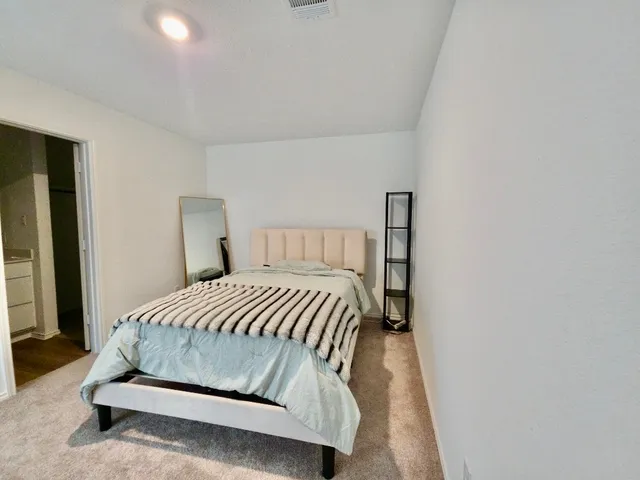 a bedroom with a bed and a night stand