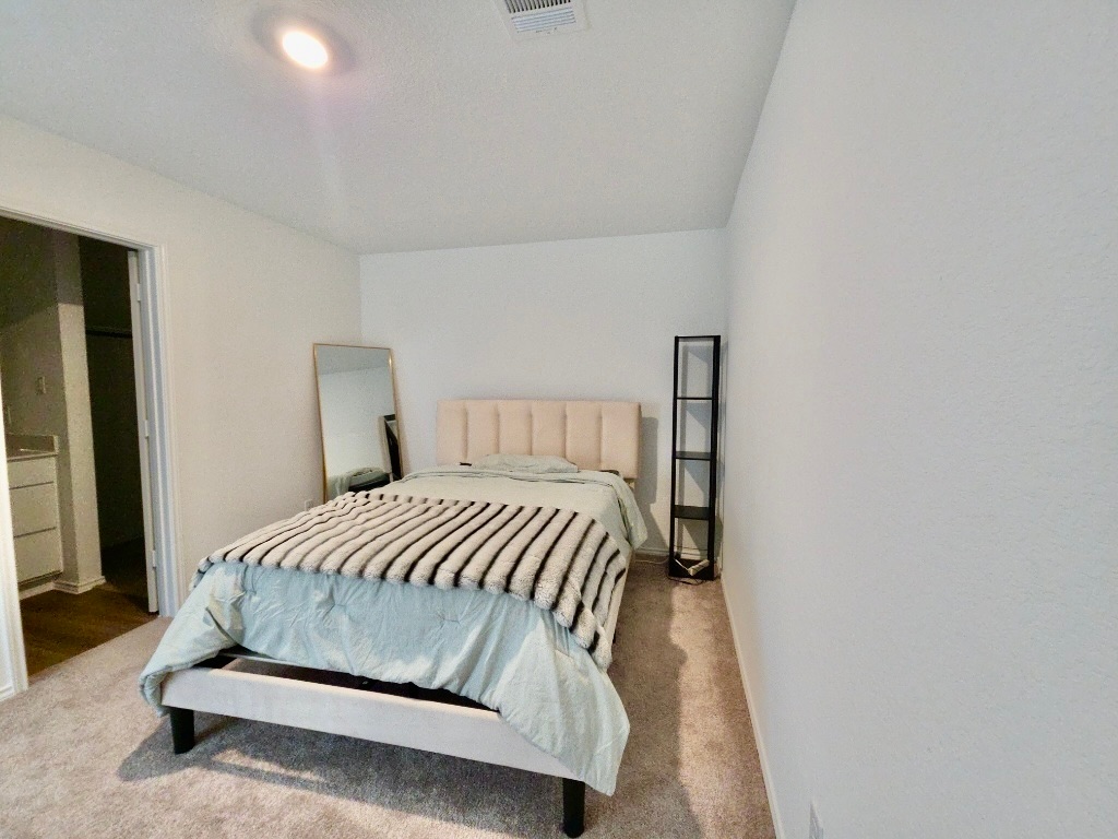 1489 Soapstone Pass Maxwell, TX 78656 - Photo 9 of 20 a bedroom with a bed and a night stand