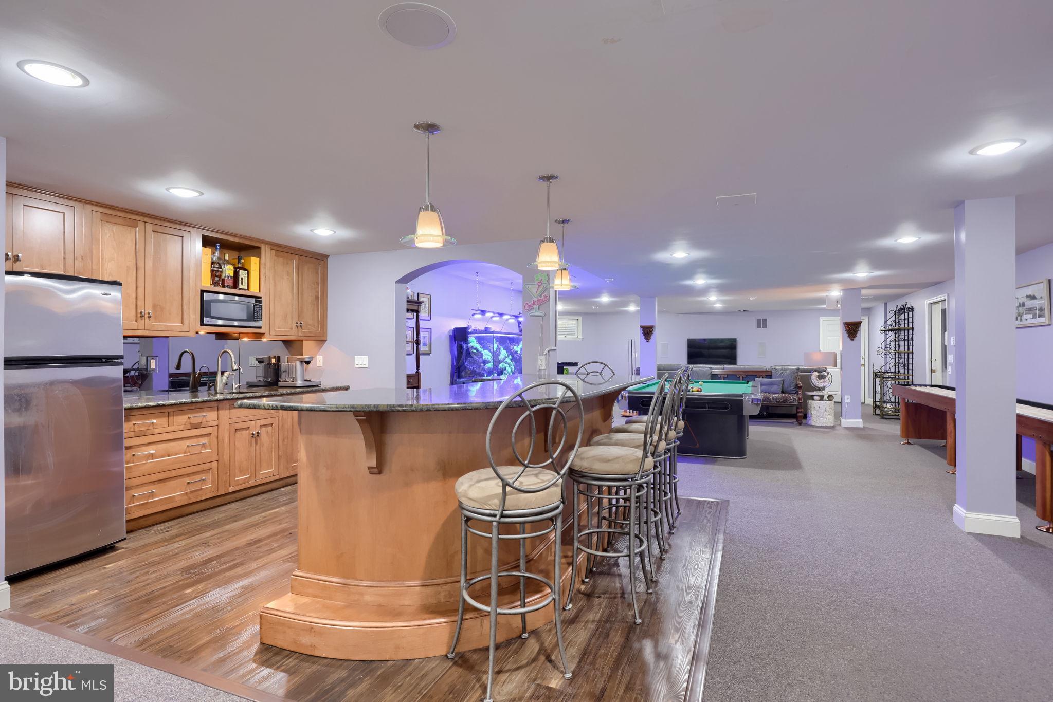 2492 Shaub Road Lancaster, PA 17601 - Photo 58 of 130 a kitchen with stainless steel appliances kitchen island granite countertop a refrigerator a sink a dining table and chairs with wooden floor