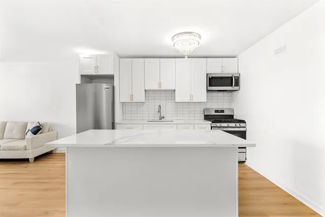 a kitchen with sink a counter and living room view