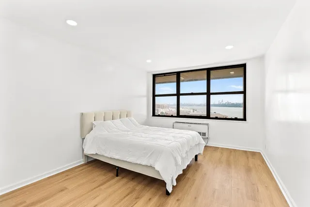 a bedroom with a bed and wooden floor