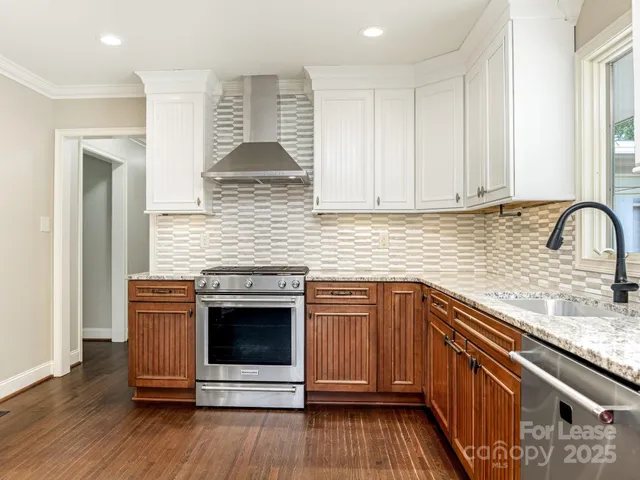a kitchen with stainless steel appliances granite countertop a sink and wooden cabinets
