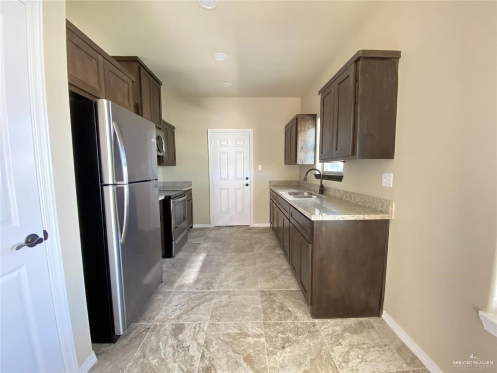 5904 Nightingale Avenue, Unit 2 Mission, TX 78573 - Photo 2 of 8 a kitchen with stainless steel appliances granite countertop a refrigerator and a sink