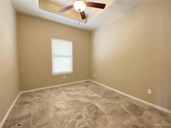 an empty room with a window and a ceiling fan
