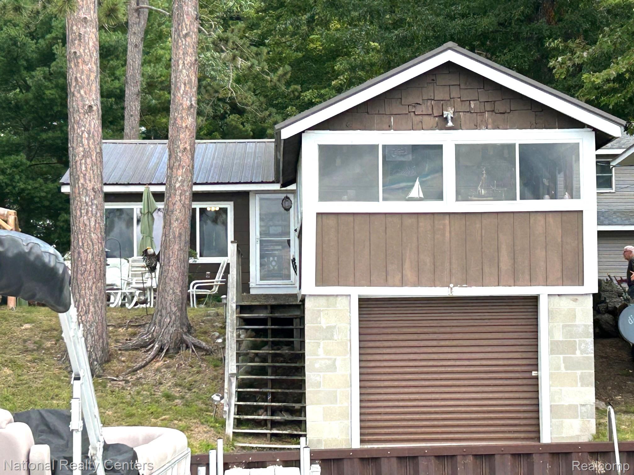 4951 Kokosing Road Hale, MI 48739 - Photo 10 of 37 View of front of house featuring a metal roof and an attached garage for storage of lake toys