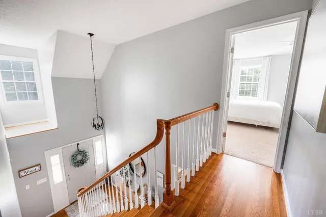 a bathroom with a granite countertop toilet a sink a mirror and a window