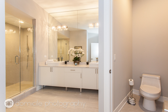 650 North Morgan Street, Unit 504 Chicago, IL 60642 - Photo 12 of 15 a bathroom with a granite countertop sink mirror vanity and toilet