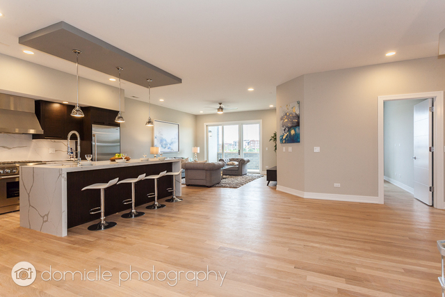 650 North Morgan Street, Unit 504 Chicago, IL 60642 - Photo 3 of 15 a view of a living room and kitchen with furniture wooden floor and window