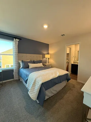 a bedroom with a bed and a view of kitchen