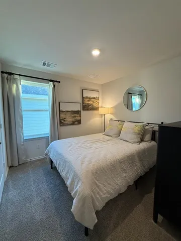 a bed sitting in a bedroom next to a window