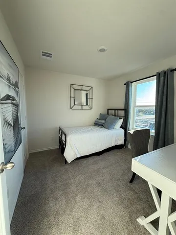 a spacious bedroom with a bed and large windows